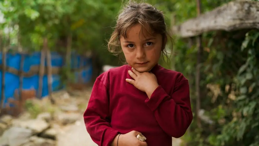 young girl looking at camera earnestly holding her throat